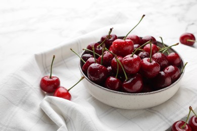 Photo of Fresh ripe cherries with water drops on towel, space for text