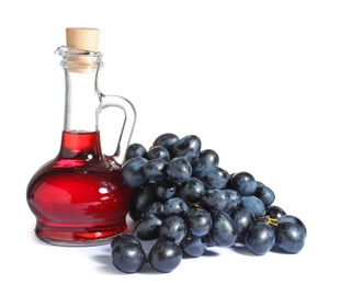 Photo of Glass jug with wine vinegar and fresh grapes on white background