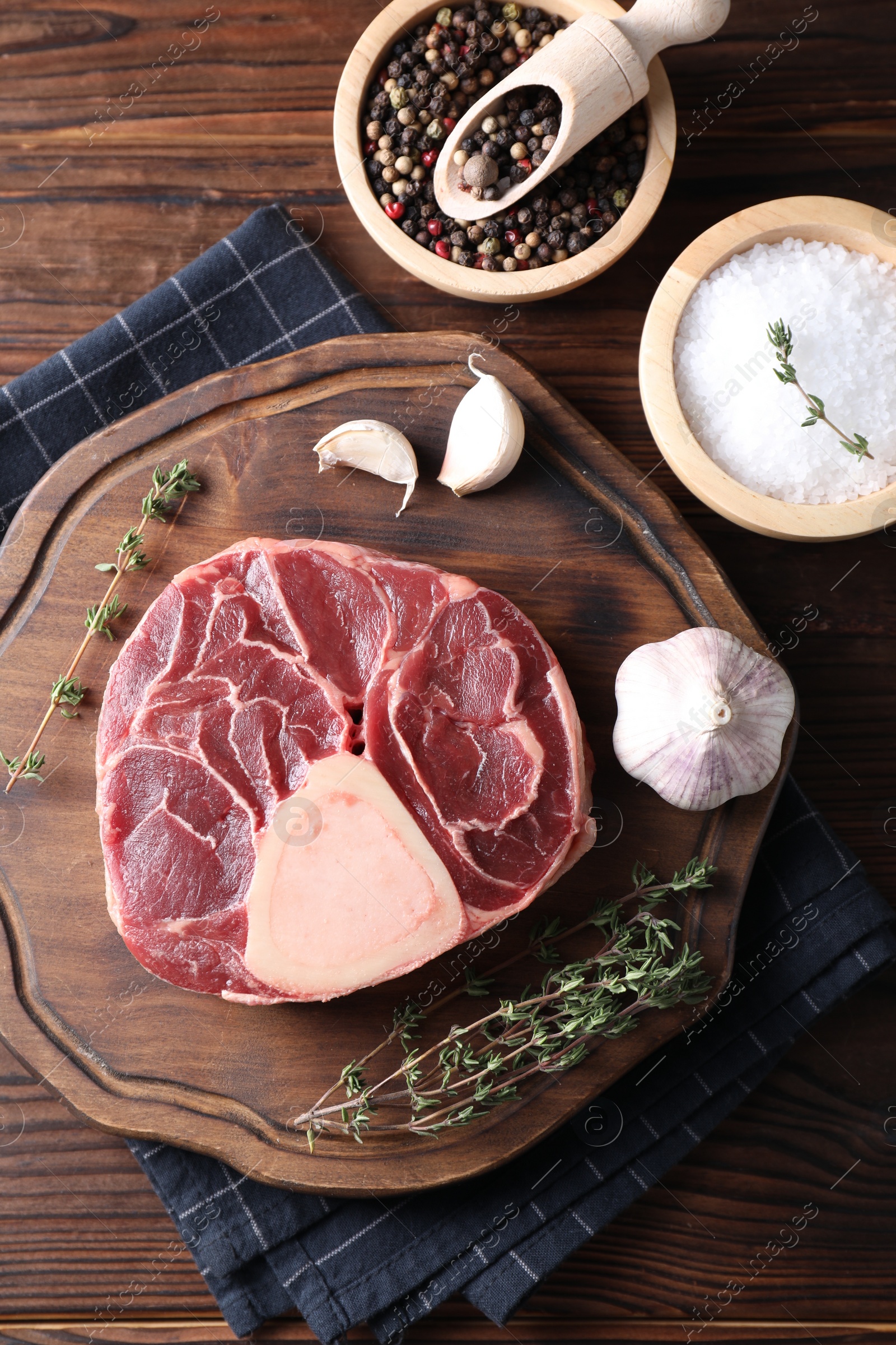 Photo of Flat lay composition of raw beef meat and spices on wooden table