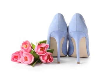 Stylish lady's shoes and beautiful spring tulips on white background. International Women's Day