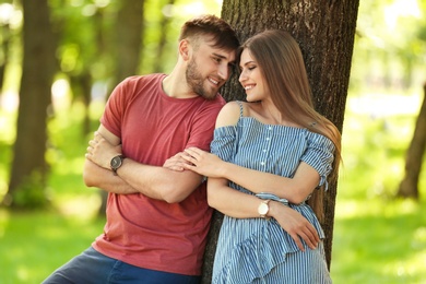 Happy young couple in green park on sunny spring day