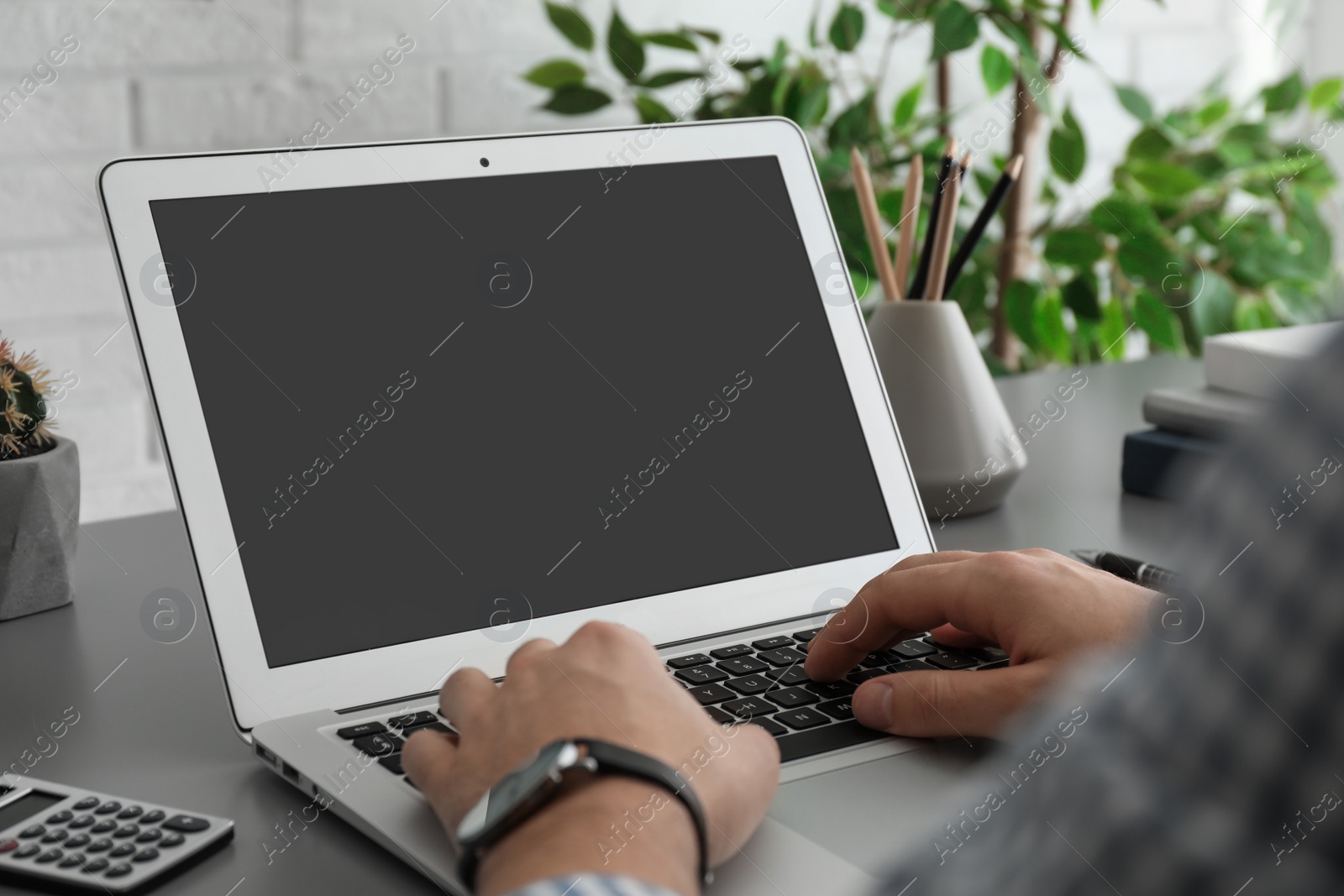 Photo of Man working with laptop at table, closeup. Space for design