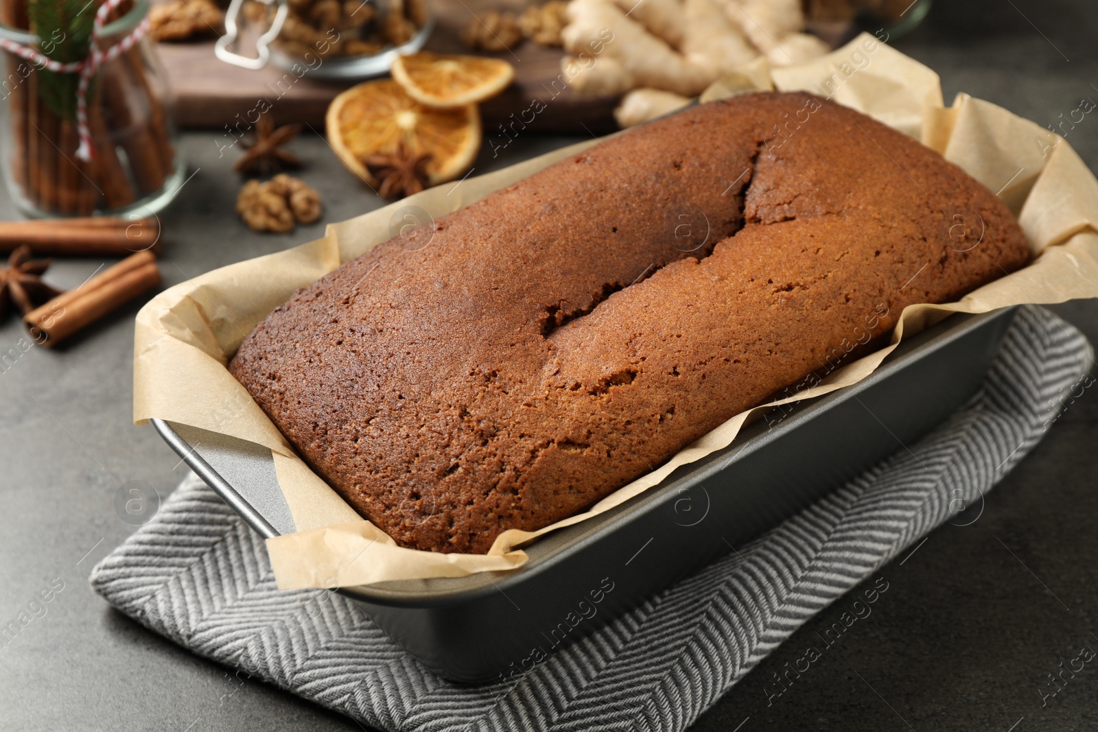 Photo of Delicious gingerbread cake in baking dish on grey table, closeup