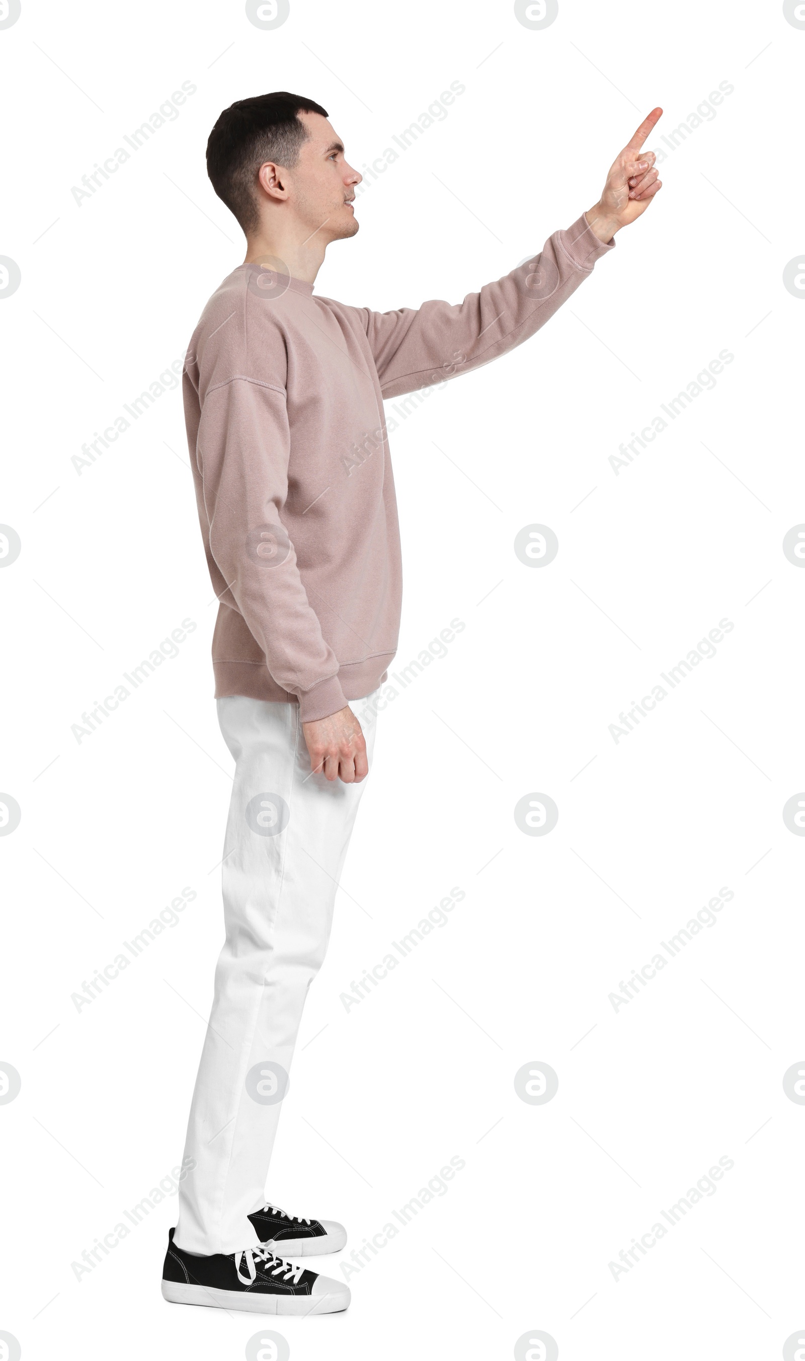 Photo of Handsome young man pointing at something on white background