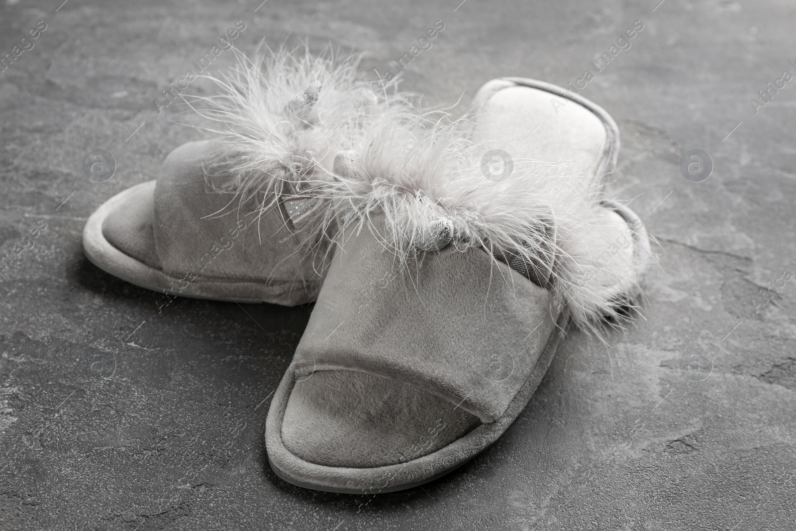 Photo of Pair of stylish soft slippers on grey background