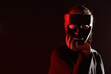 Theatrical performance. Man with plastic mask on dark background, space for text