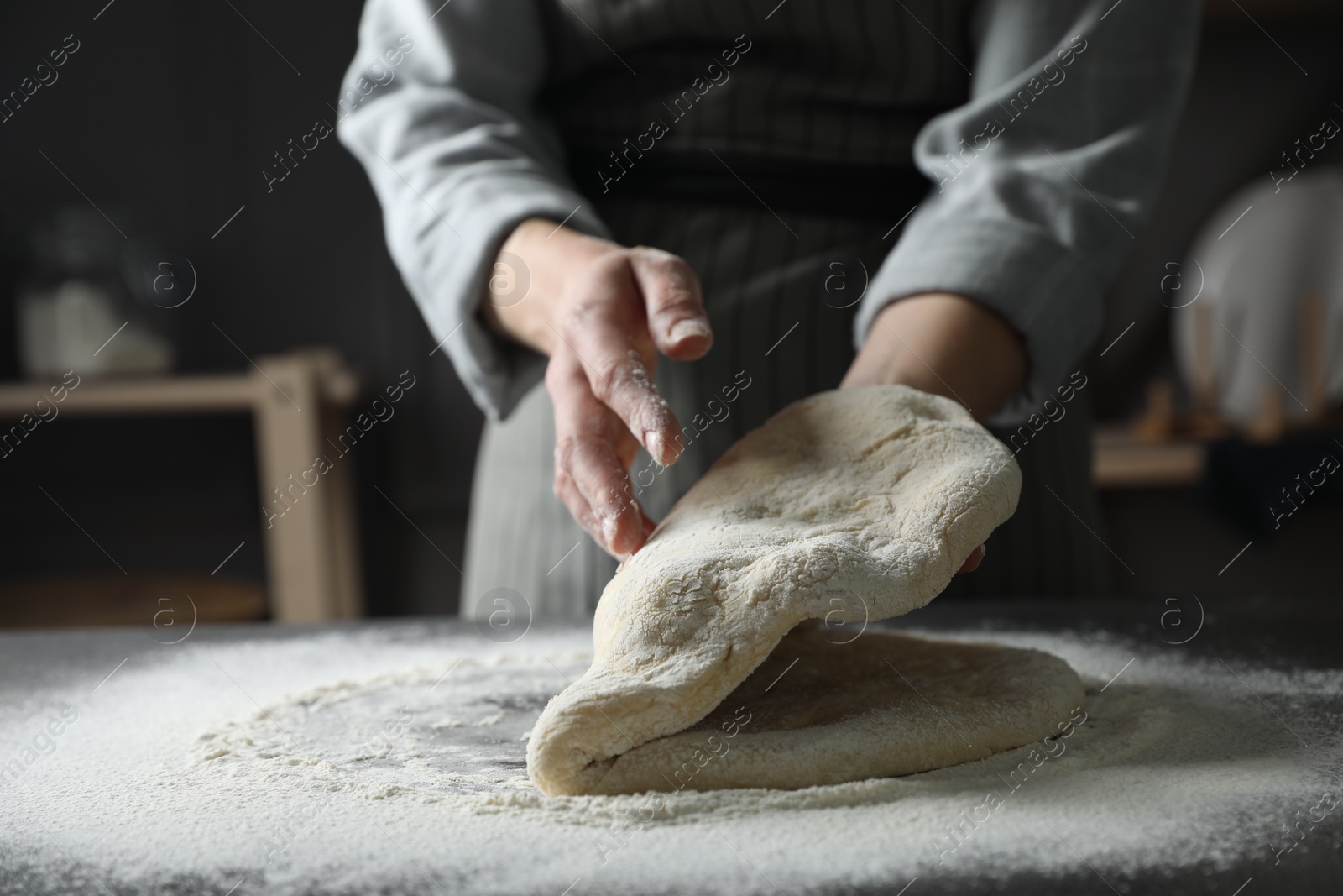 Photo of Woman making pizza dough at table, closeup