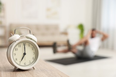 Photo of Man doing morning exercise on fitness mat at home, selective focus. Space for text