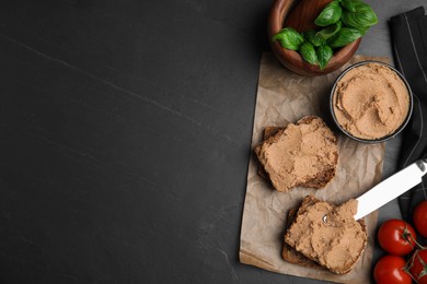 Photo of Fresh bread with delicious meat pate, cherry tomatoes and basil on black table, flat lay. Space for text