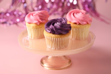 Photo of Delicious cupcakes with bright cream on pink background, closeup