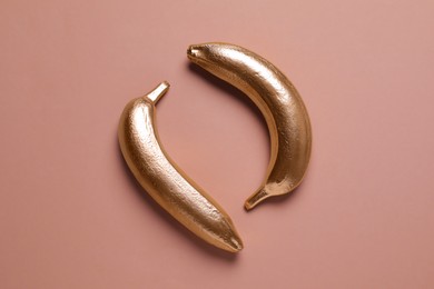 Golden banana on pale pink background, flat lay