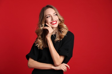 Photo of Happy young woman on red background. Christmas celebration
