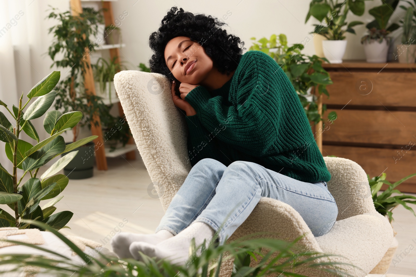 Photo of Woman relaxing surrounded by beautiful houseplants at home