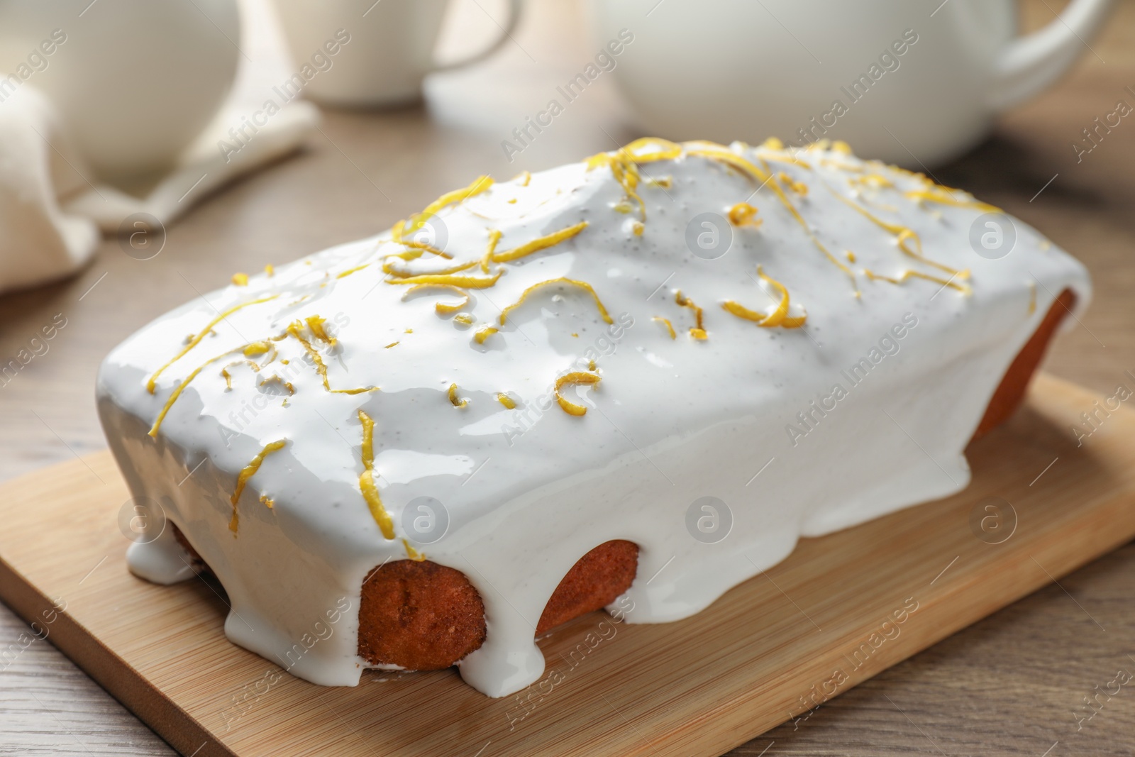 Photo of Tasty lemon cake with glaze on wooden table, closeup