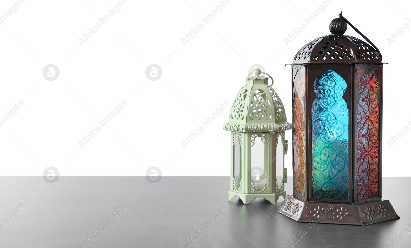 Photo of Decorative Arabic lanterns on grey table against white background