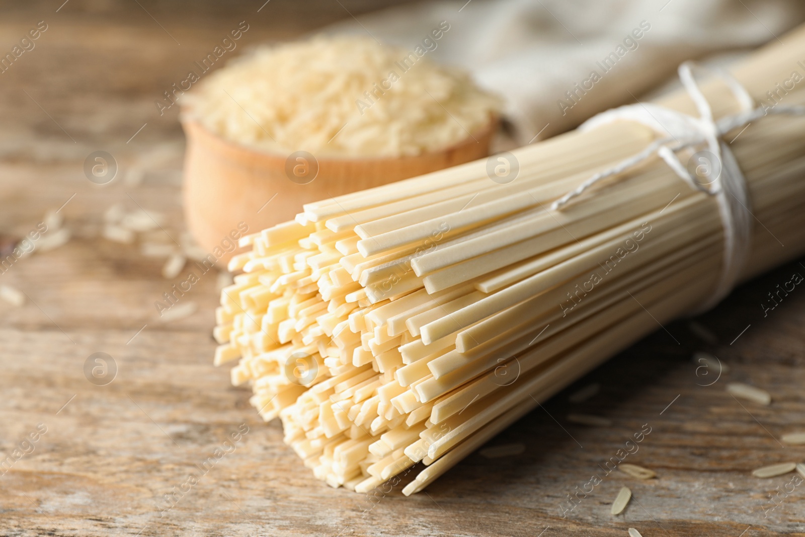 Photo of Raw rice noodles on wooden table, closeup