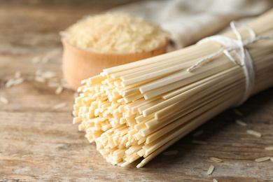 Raw rice noodles on wooden table, closeup