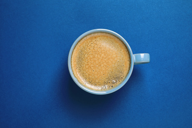 Photo of Classic black coffee on blue background, top view. Color of the year 2020