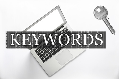 Image of Word Keywords, laptop and key on white background, top view. SEO direction