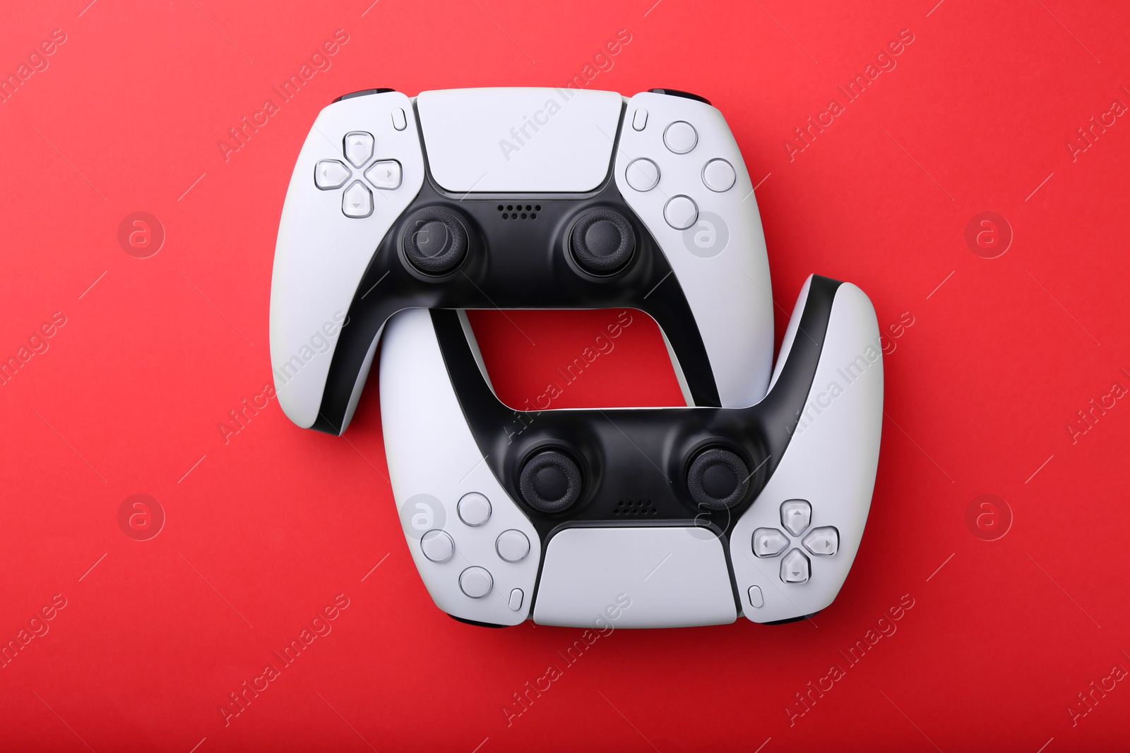 Photo of Wireless game controllers on red background, flat lay