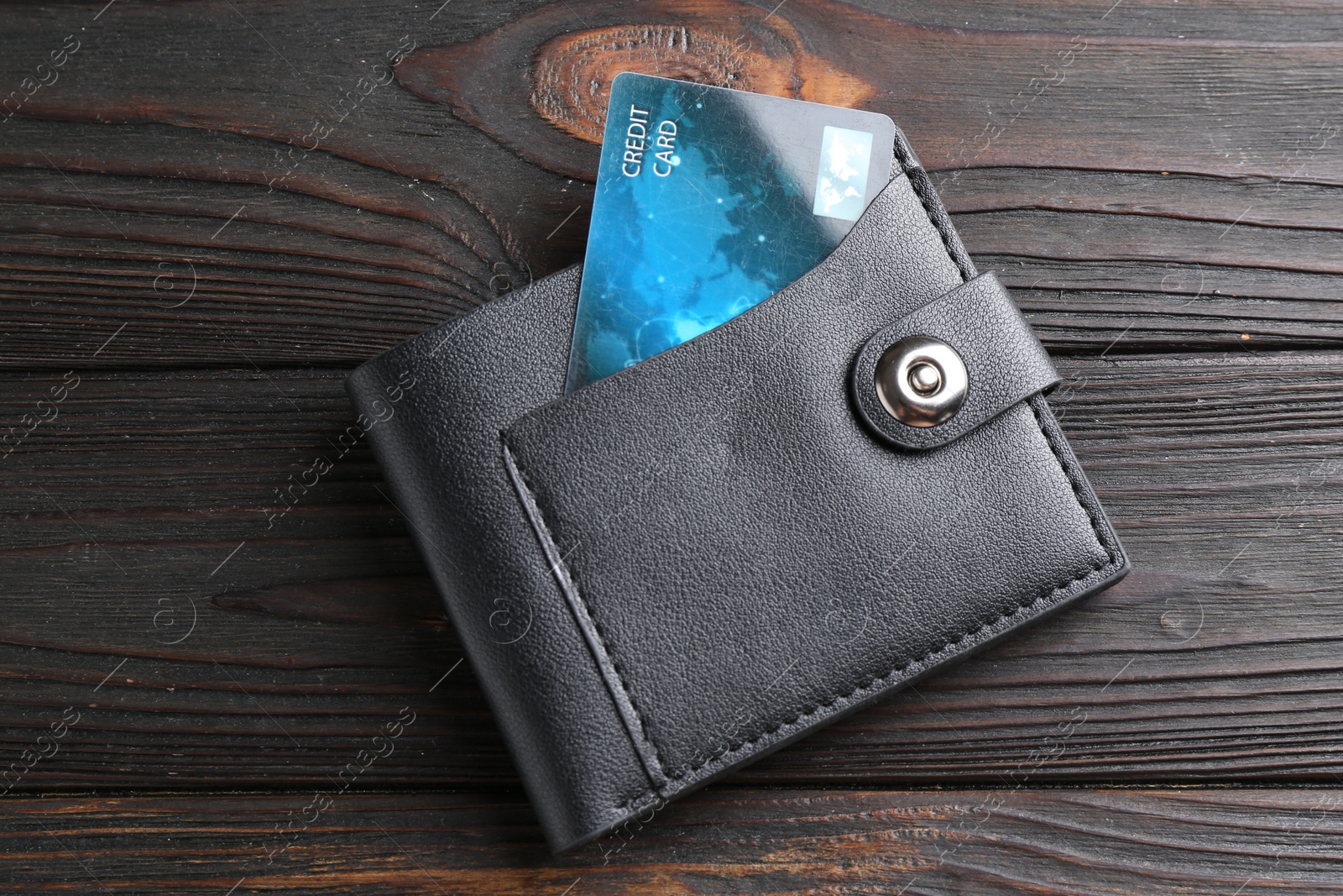 Photo of Credit card in leather wallet on wooden table, top view