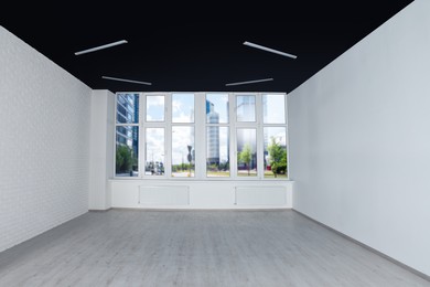 Empty office room with black ceiling and clean windows. Interior design