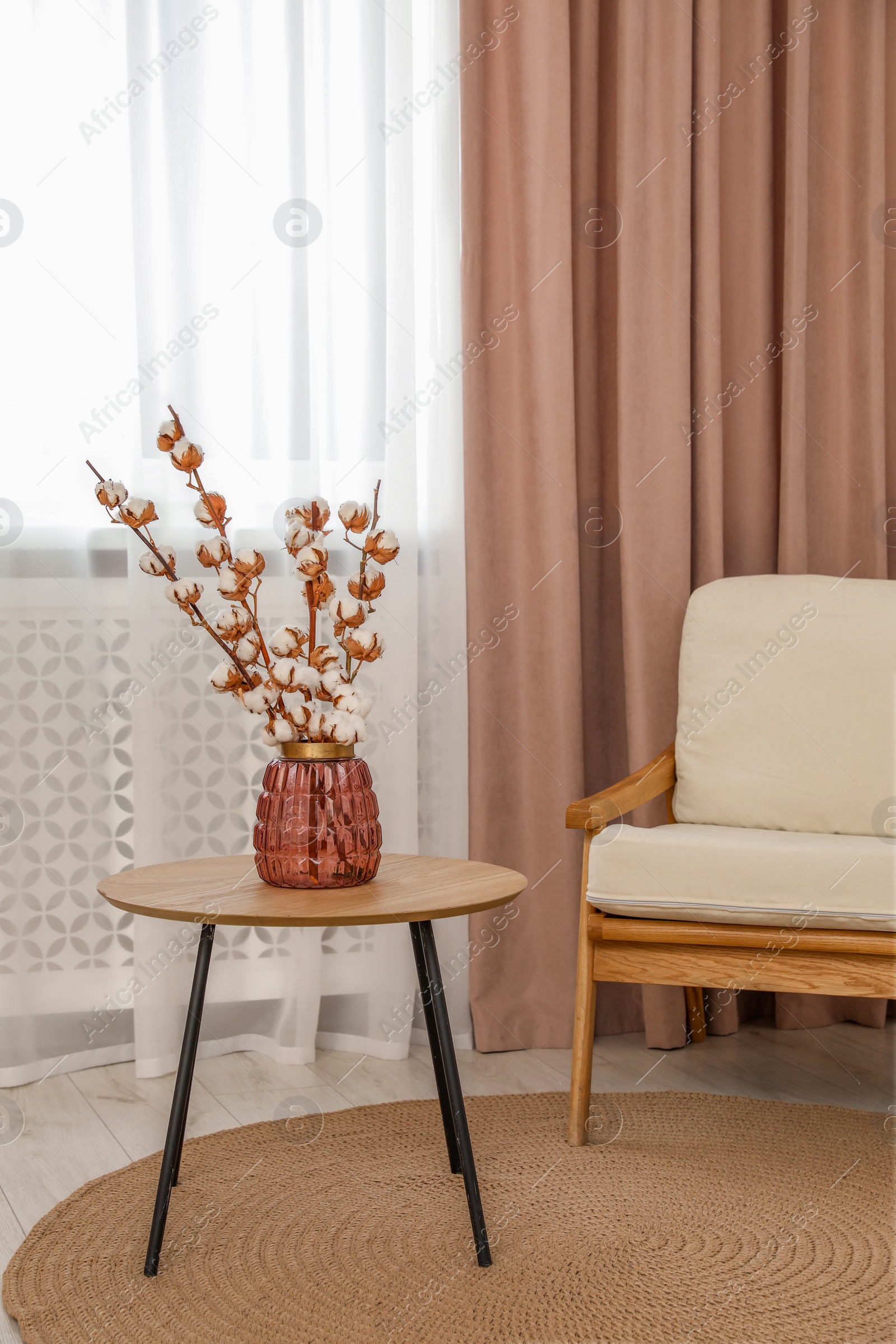 Photo of Living room with pastel window curtain, wooden table and armchair