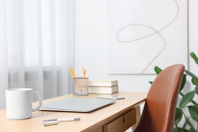 Photo of Home office. Stylish workplace with laptop and stationery on wooden desk indoors. Space for text