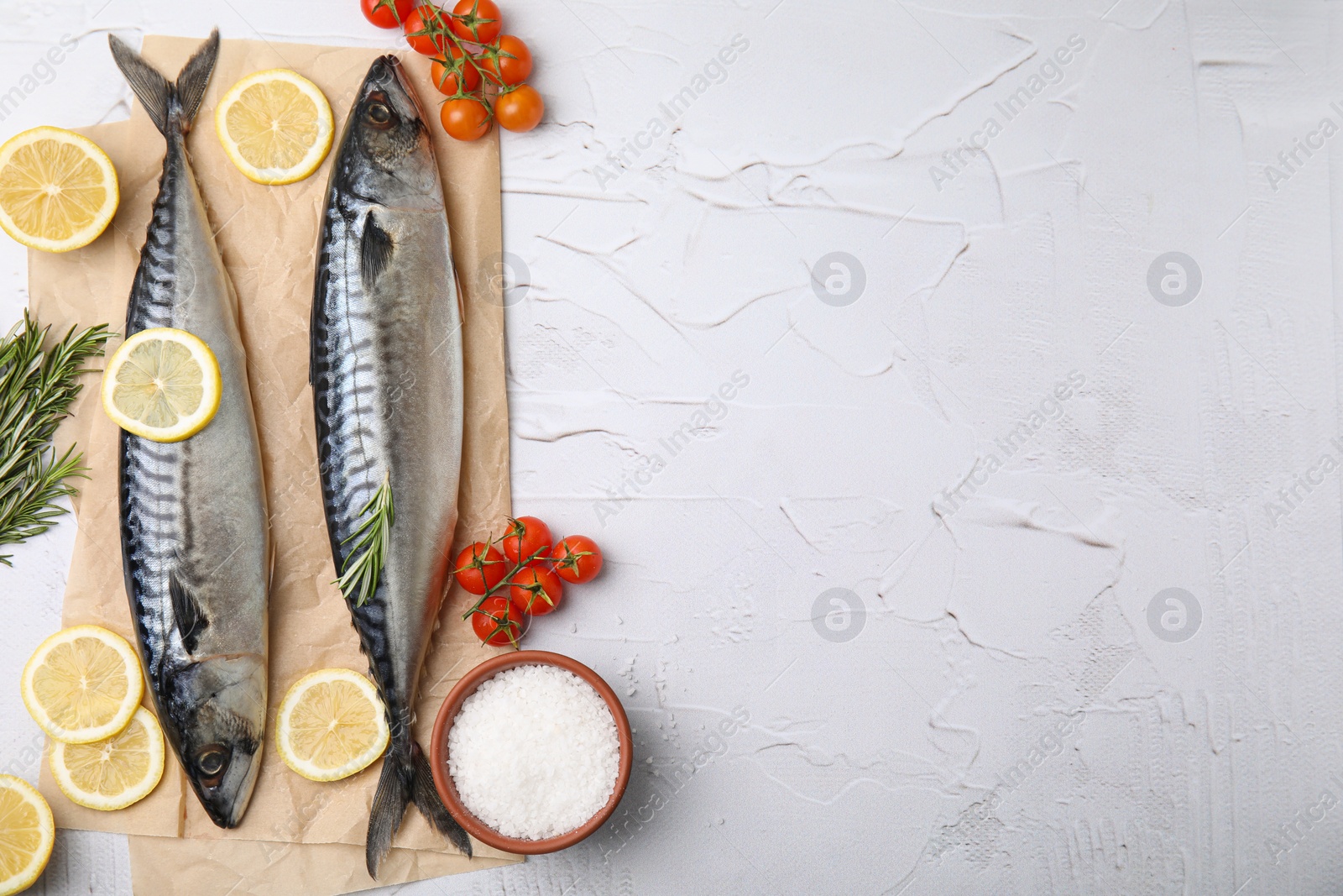 Photo of Tasty raw mackerel and ingredients on white textured table, flat lay. Space for text