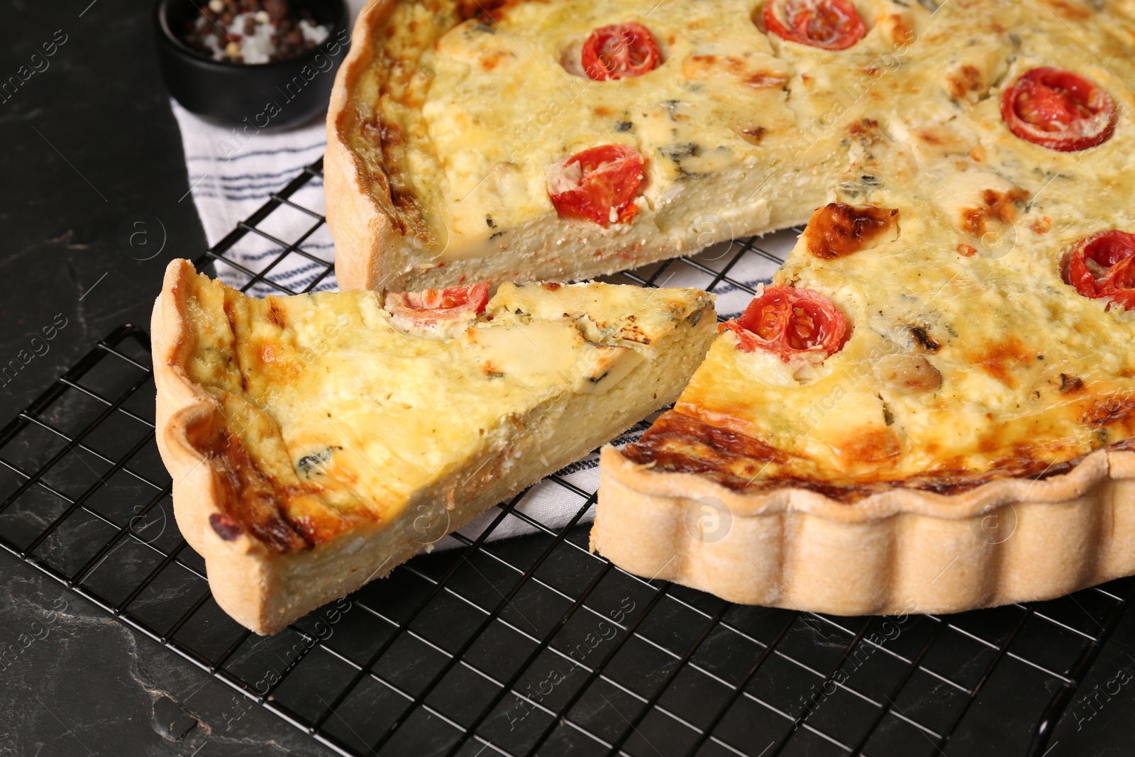 Photo of Delicious homemade cheese quiche on black table, closeup