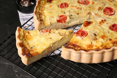 Photo of Delicious homemade cheese quiche on black table, closeup