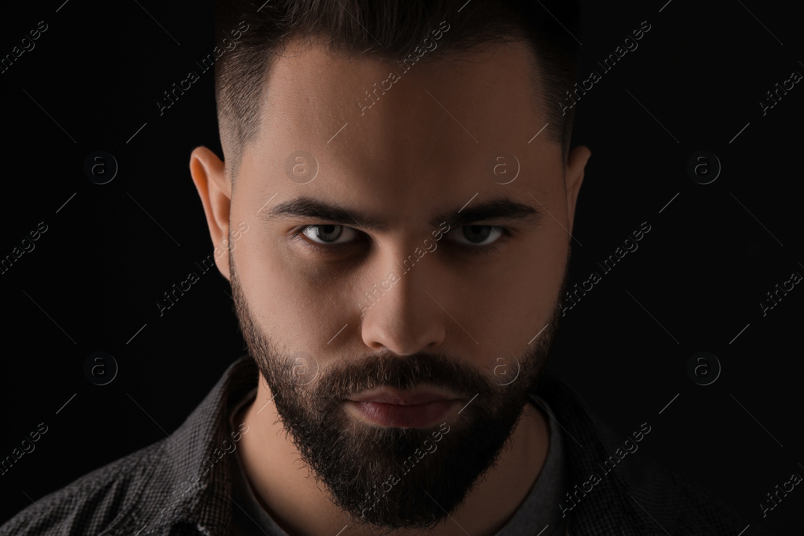 Photo of Evil eye. Man with scary eyes on black background