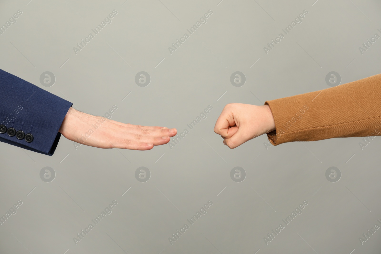 Photo of People playing rock, paper and scissors on grey background, closeup