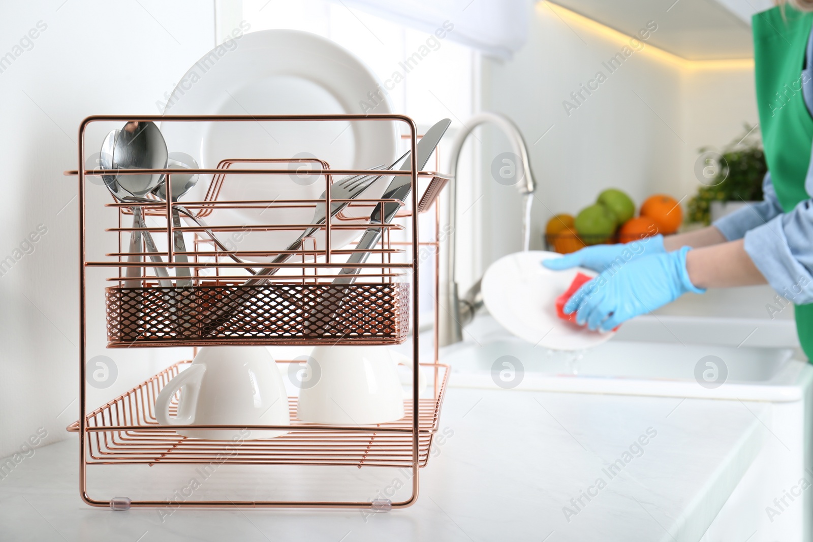 Photo of Woman washing plate in modern kitchen, closeup