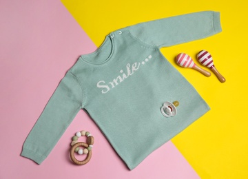 Photo of Flat lay composition with sweater and children's toys on color background