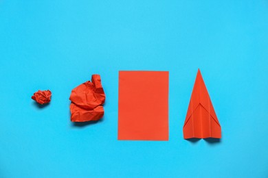 Photo of Making paper plane, trial and error. Flat lay composition with crumpled and folded sheets on light blue background