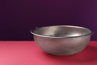 Photo of One clean empty colander on color background, closeup