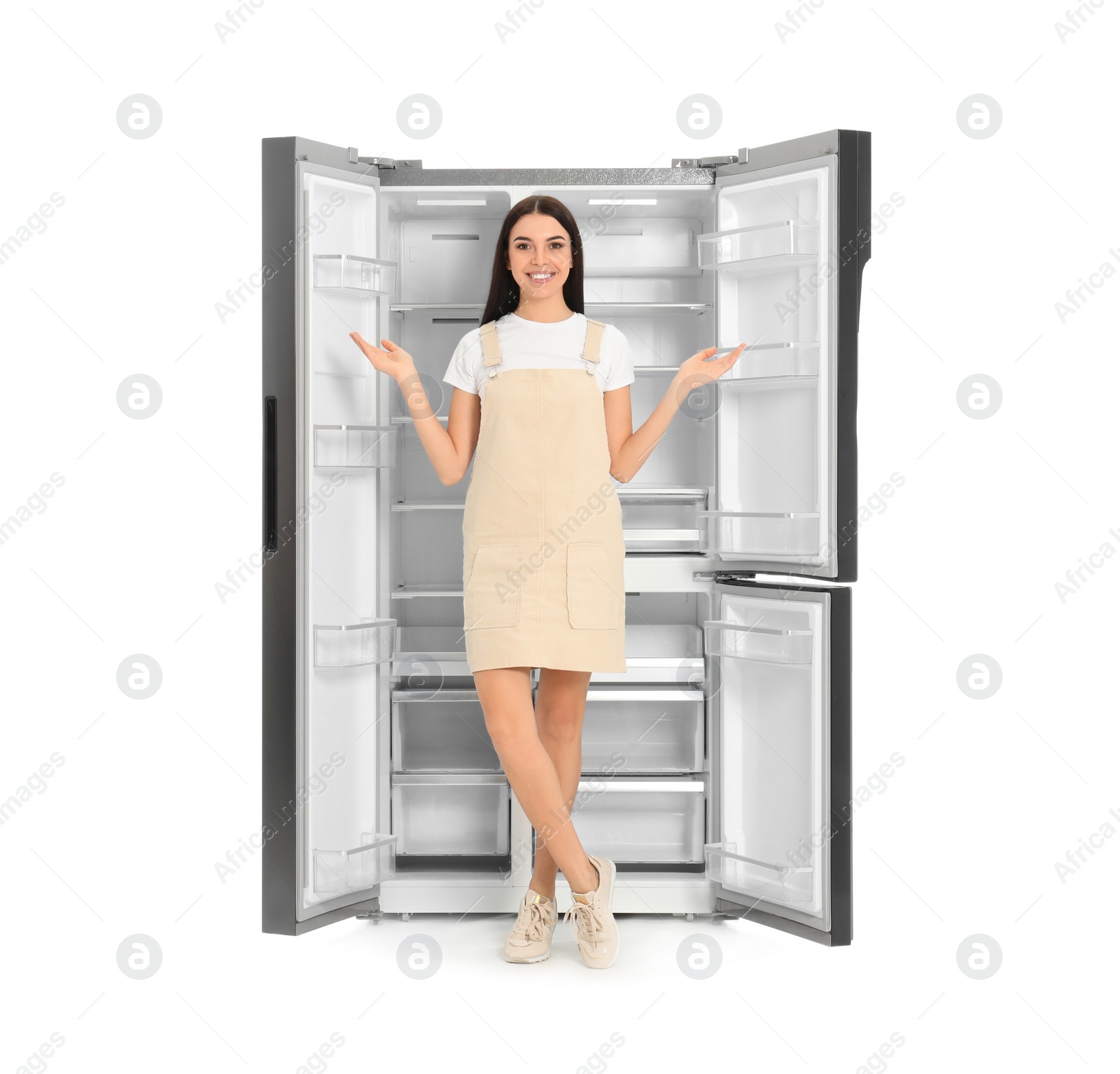 Photo of Young woman near empty refrigerator on white background