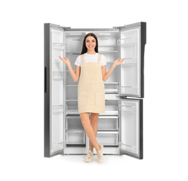 Photo of Young woman near empty refrigerator on white background