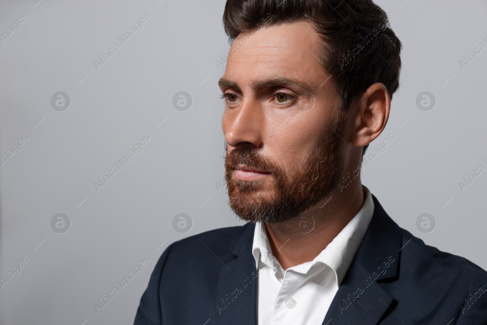 Photo of Handsome bearded man in suit on light grey background. Space for text