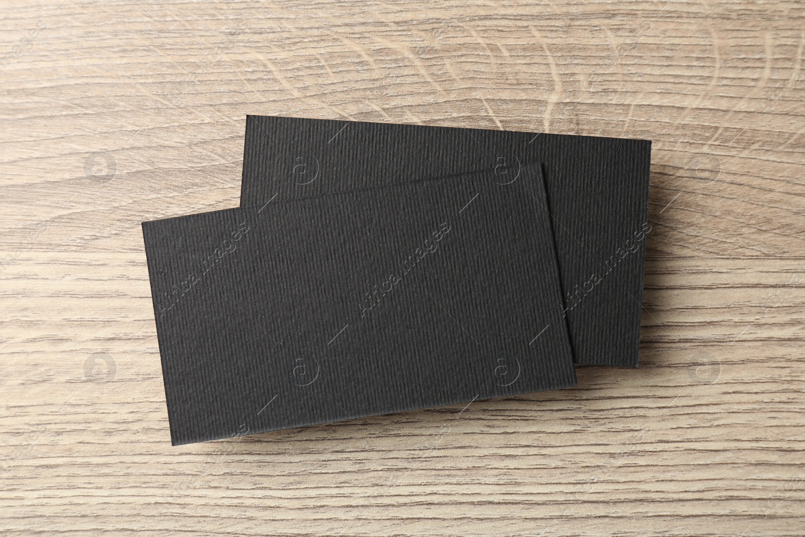 Photo of Blank black business cards on wooden table, top view. Mockup for design