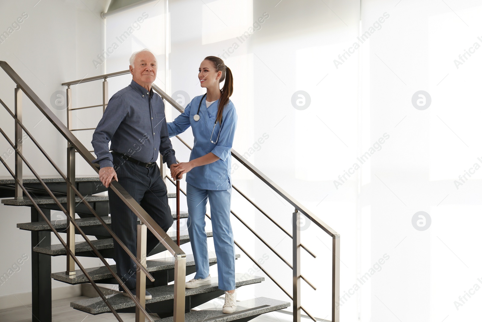 Photo of Doctor helping senior patient in modern hospital