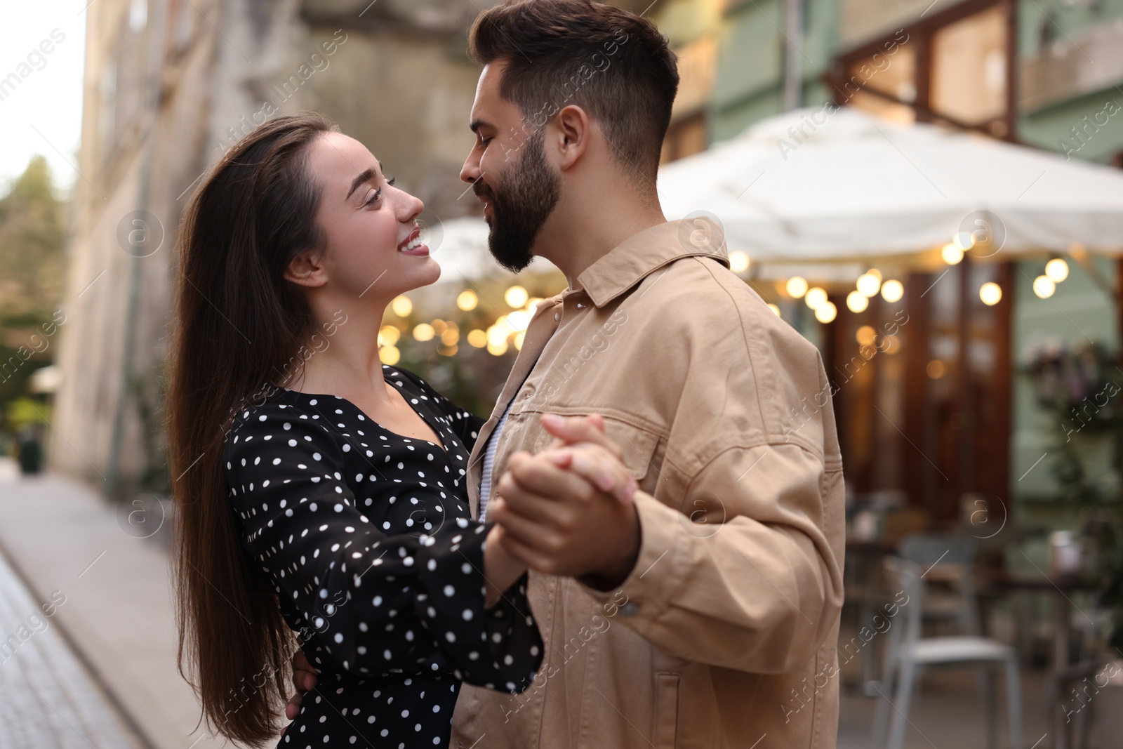 Photo of Lovely couple dancing together on city street