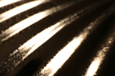 Blurred view of corrugated golden texture as background