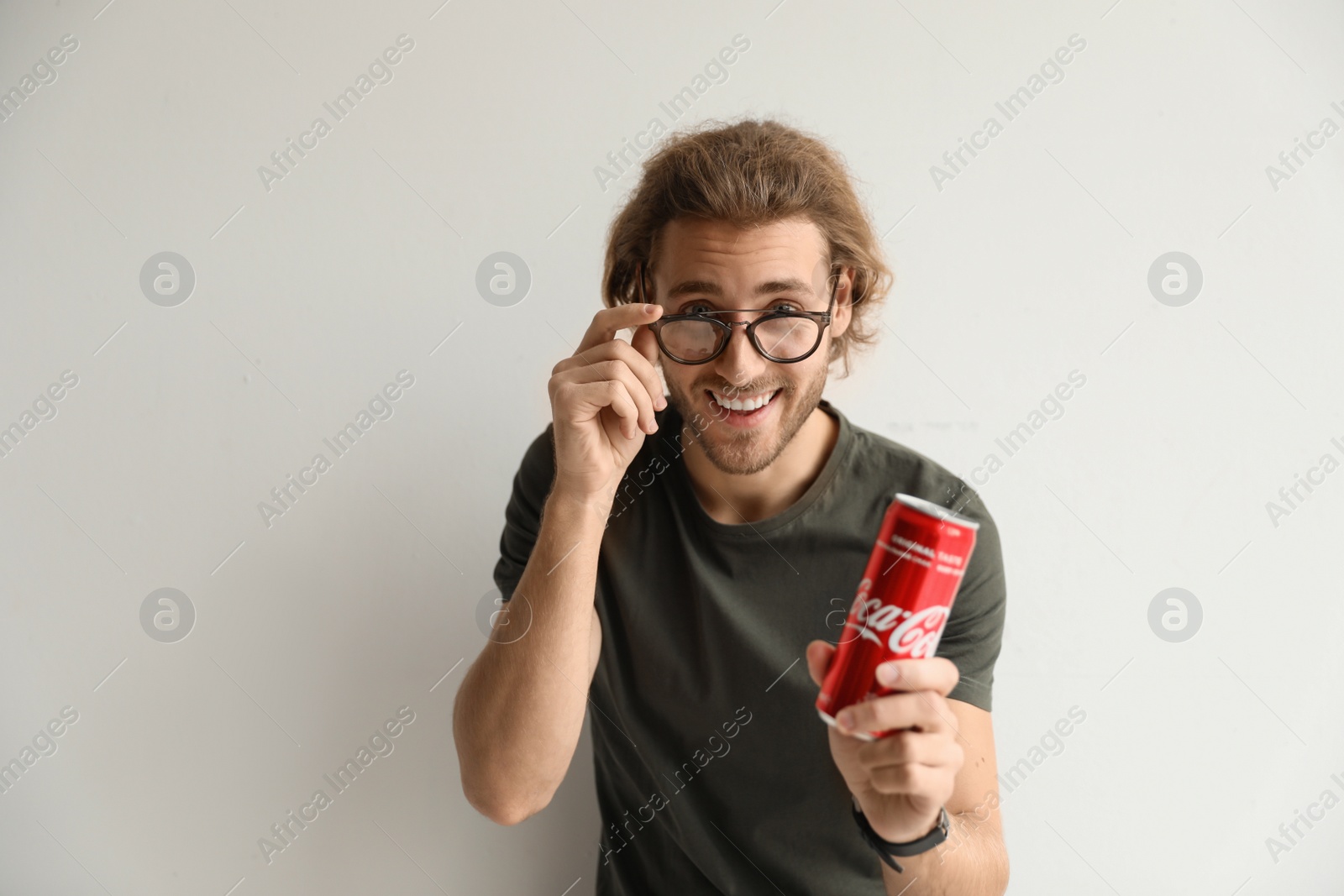 Photo of MYKOLAIV, UKRAINE - NOVEMBER 28, 2018: Young man with Coca-Cola can on white background