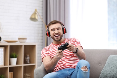 Emotional young man playing video game at home