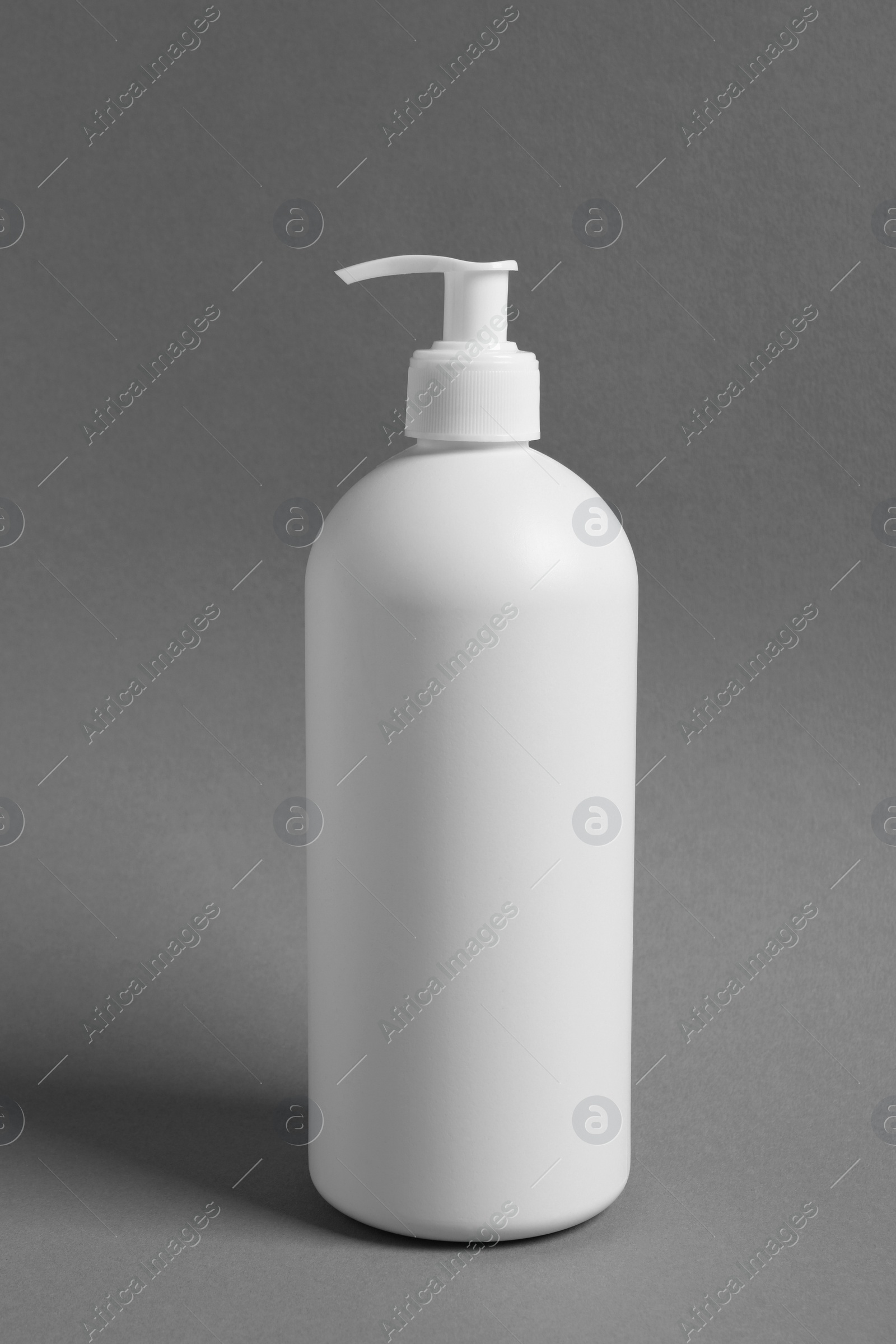 Photo of Bottle with cosmetic product on grey background