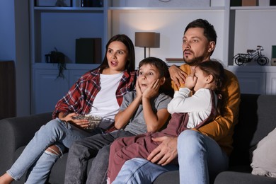 Photo of Emotional family watching TV at home in evening