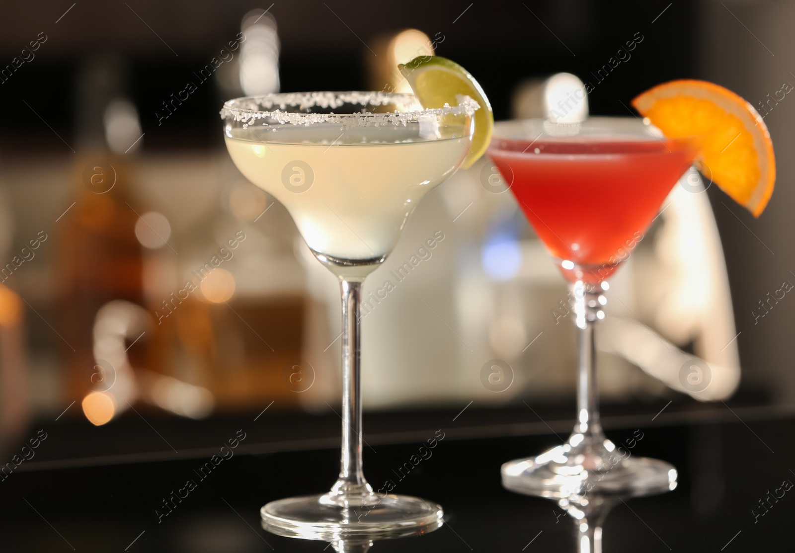 Photo of Different delicious cocktails on counter in bar