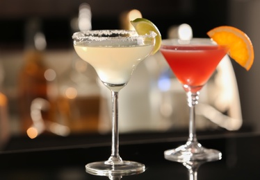 Photo of Different delicious cocktails on counter in bar